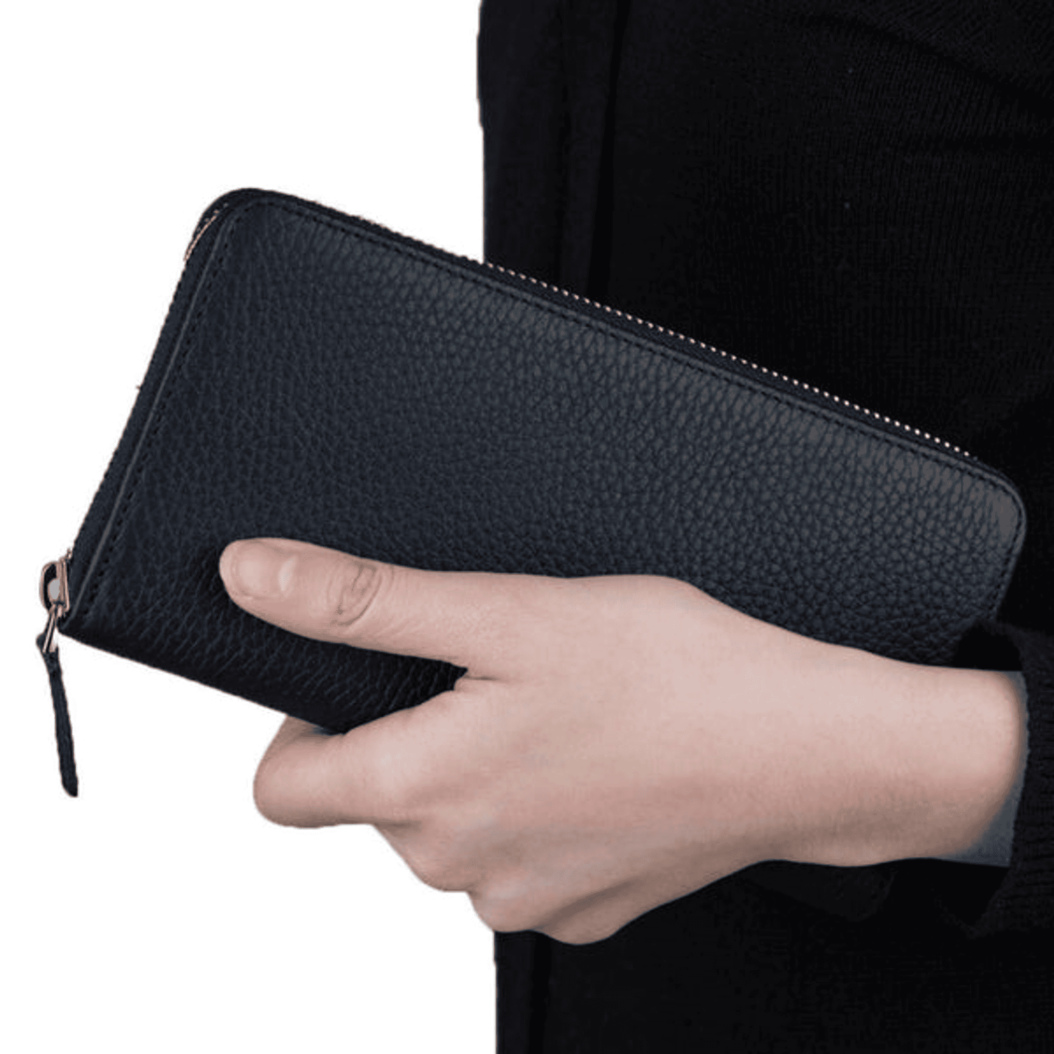 Black full-grain leather zippered clutch held in hand