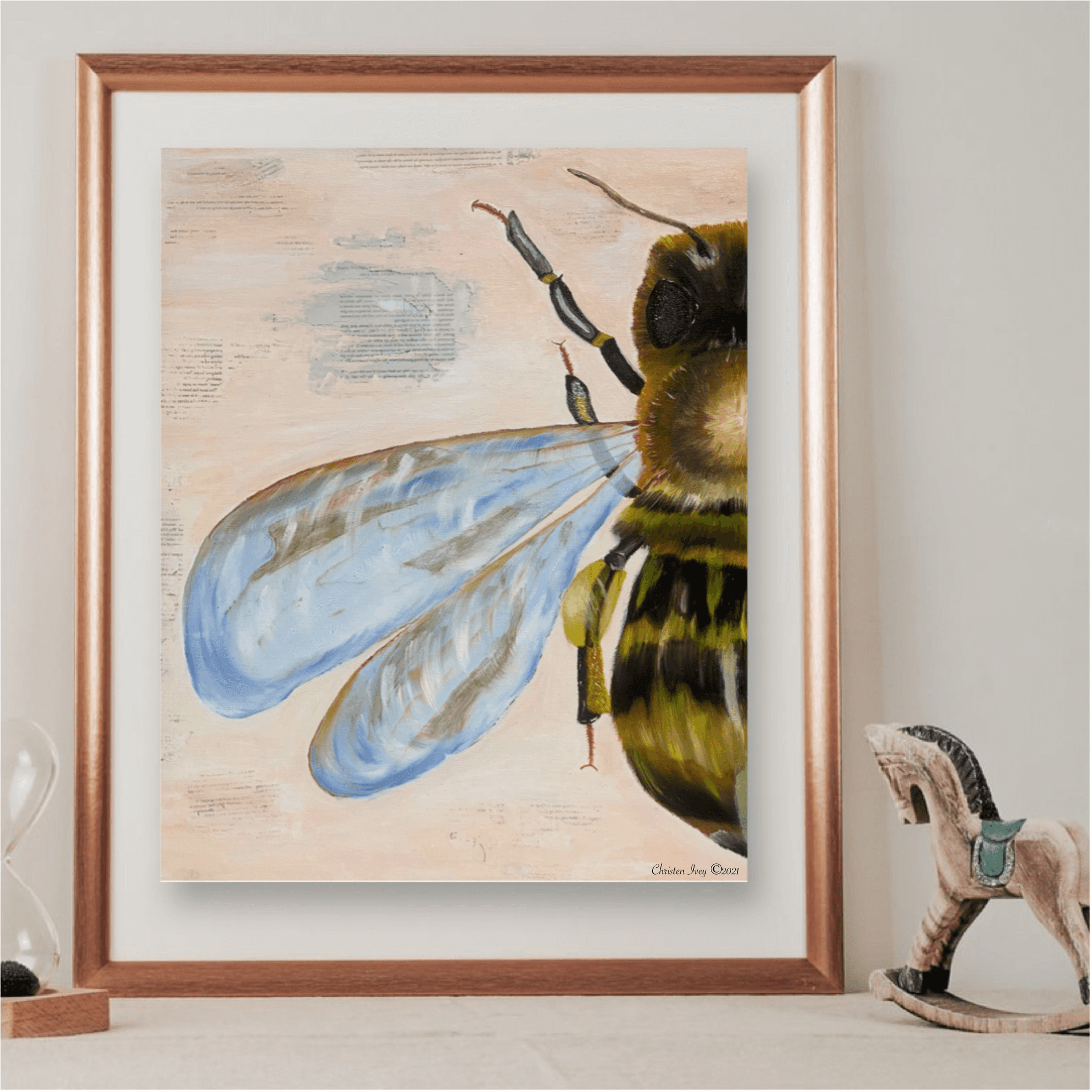 Framed bee wall art print with blue wings and yellow-green body on light background
