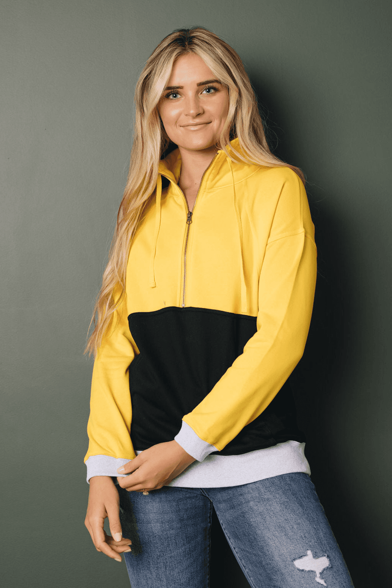 Yellow zip-up colorblock sweatshirt with black panel and white sleeve cuffs