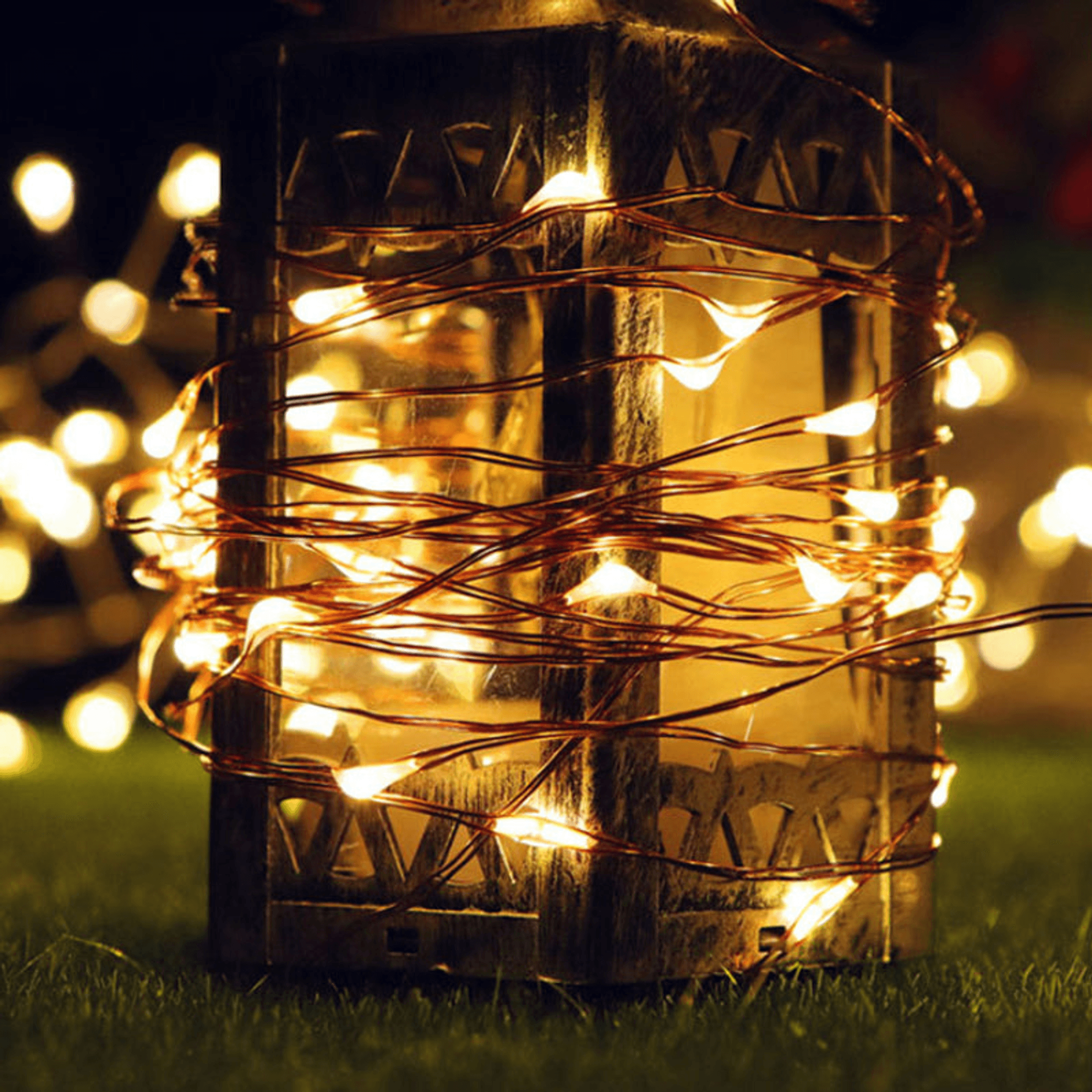 Mini home string lights with warm white LEDs, lit wire wrapped around a wooden lantern