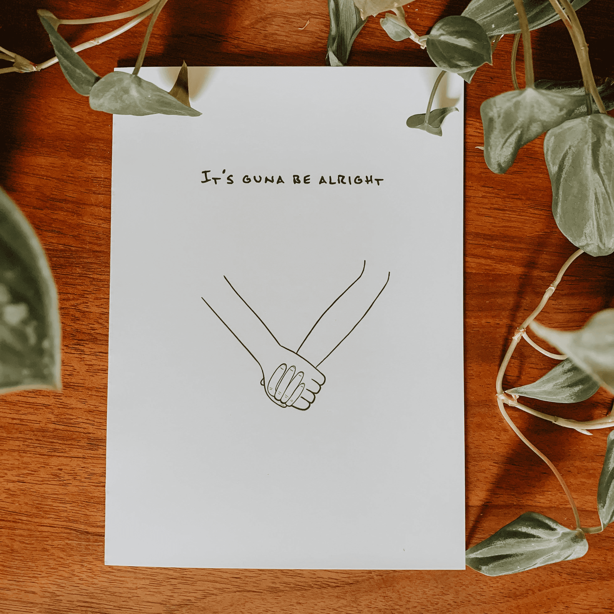 White greeting card with 'It's guna be alright' and line-art handshake.
