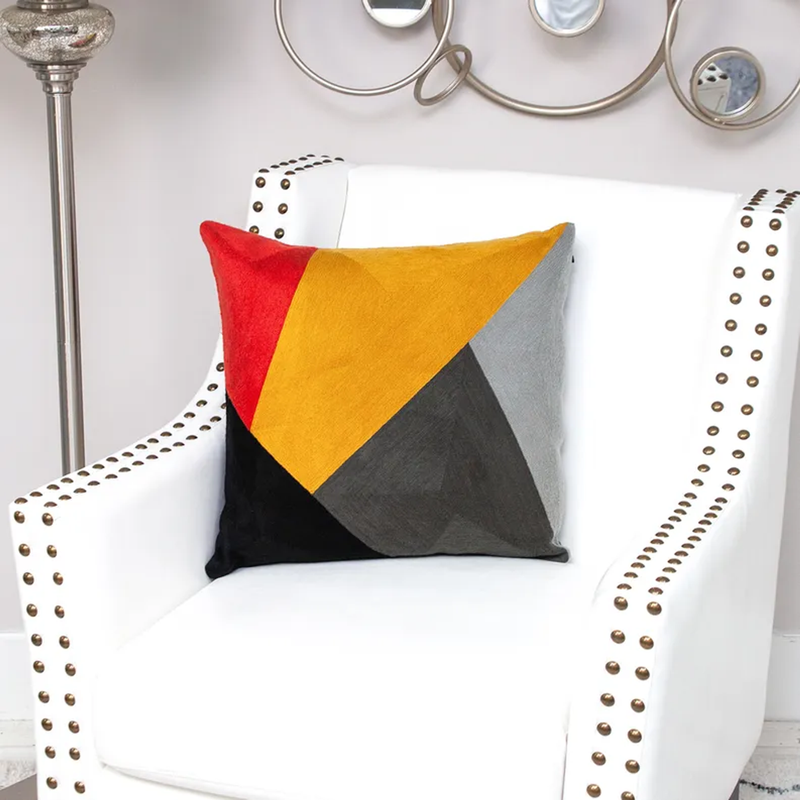 Multicolor pillow cover with geometric triangles in red, yellow, gray, and black