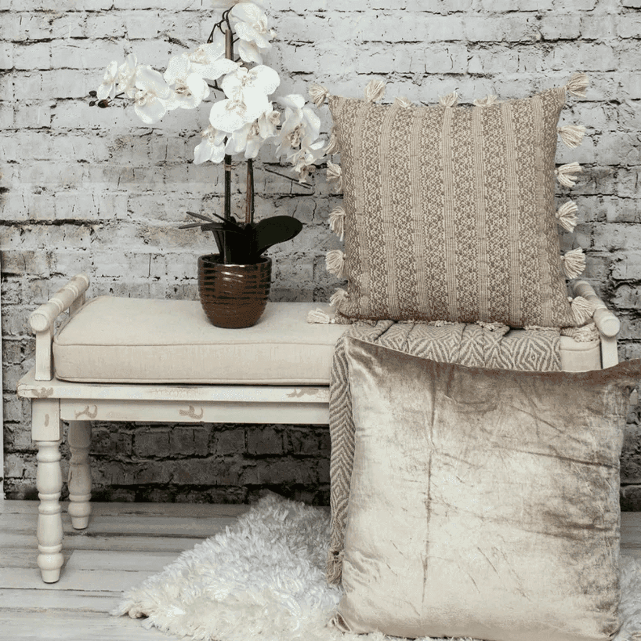 Beige striped throw pillow with tassel fringe and textured woven fabric on the seat.