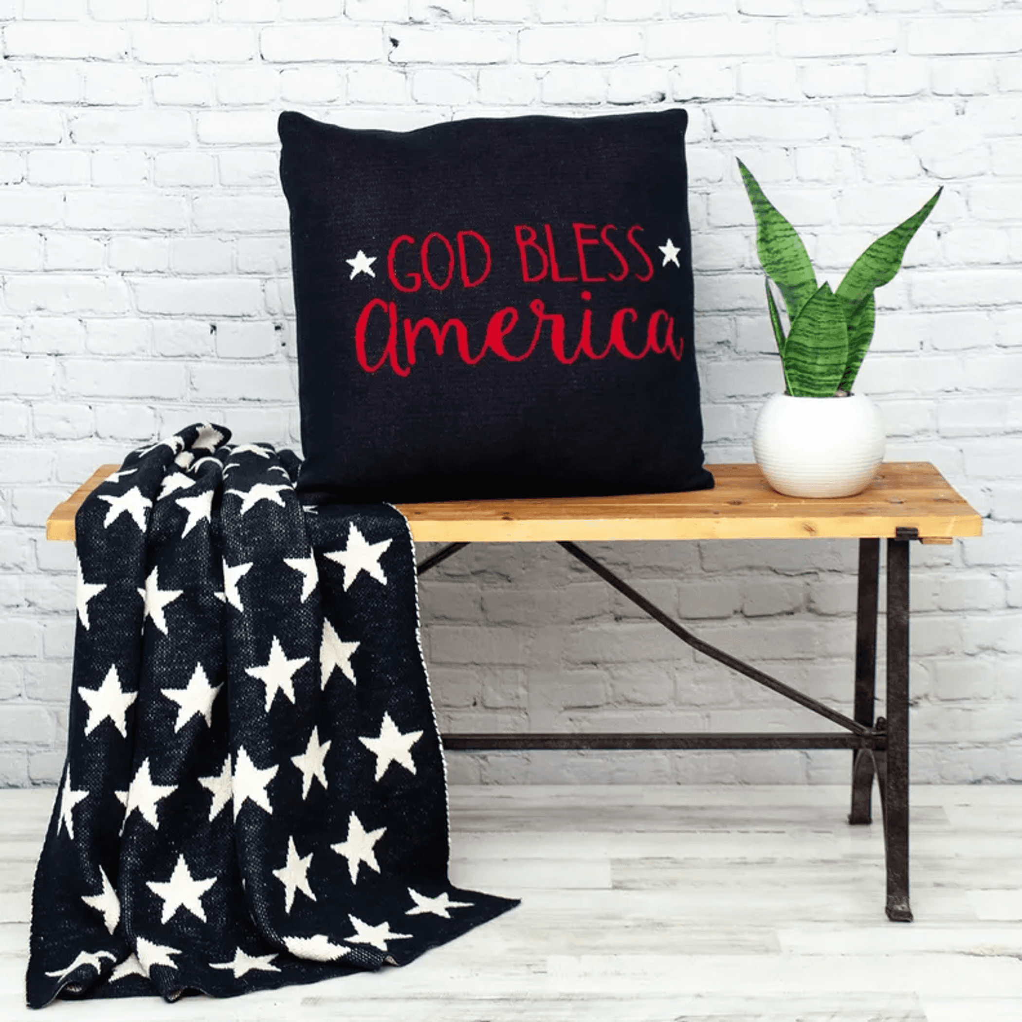 Navy throw pillow with red “GOD BLESS America” lettering and white star accents