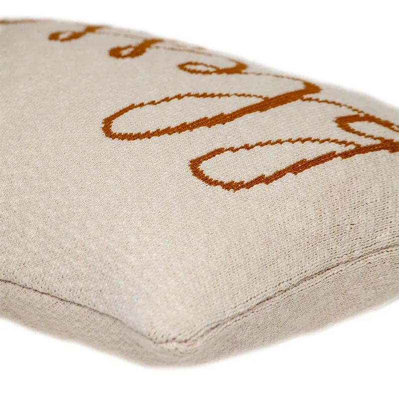 Beige throw pillow corner with embroidered 'Blessed' outline