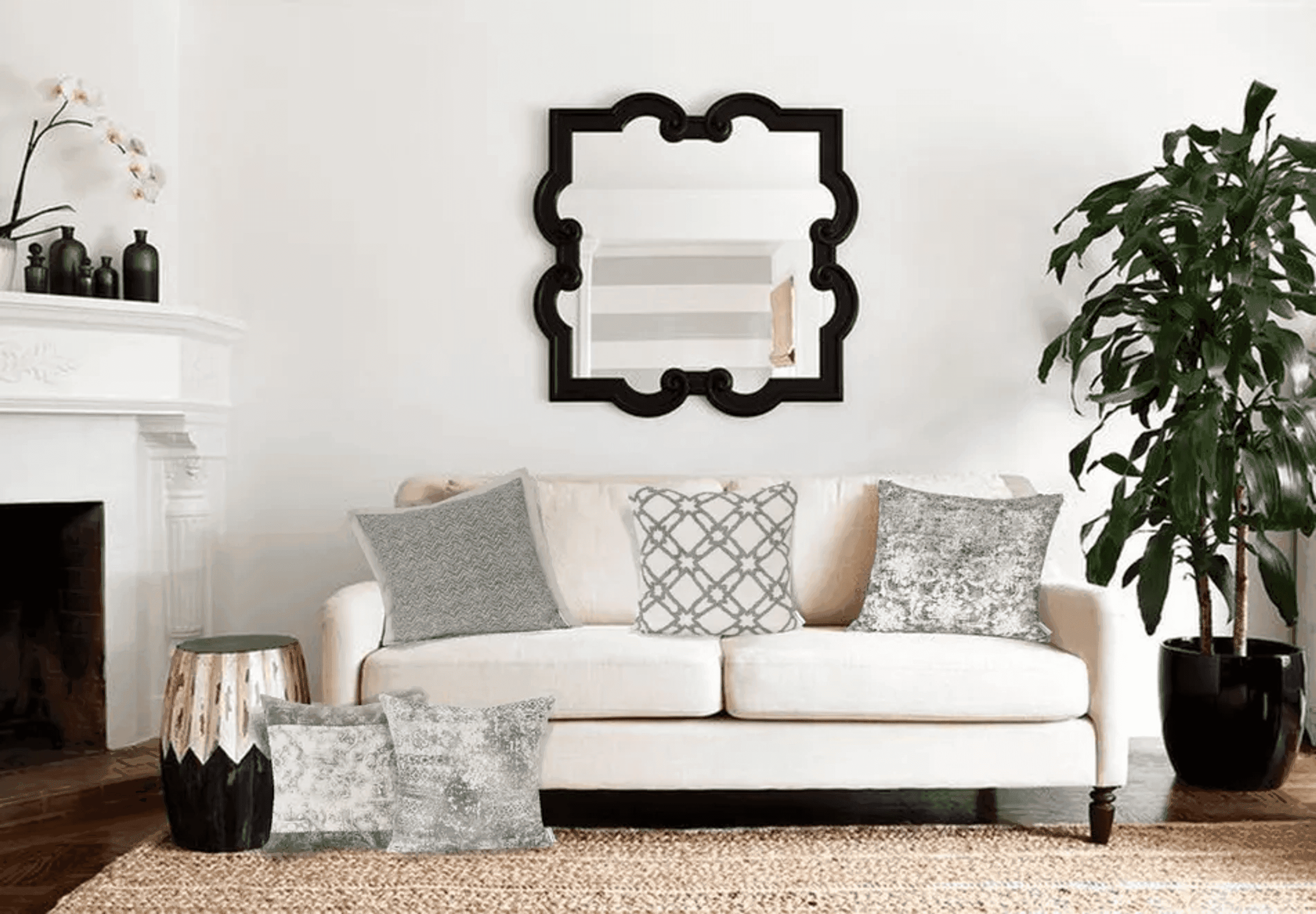 Decorative gray ornate print square throw pillow on a light sofa.