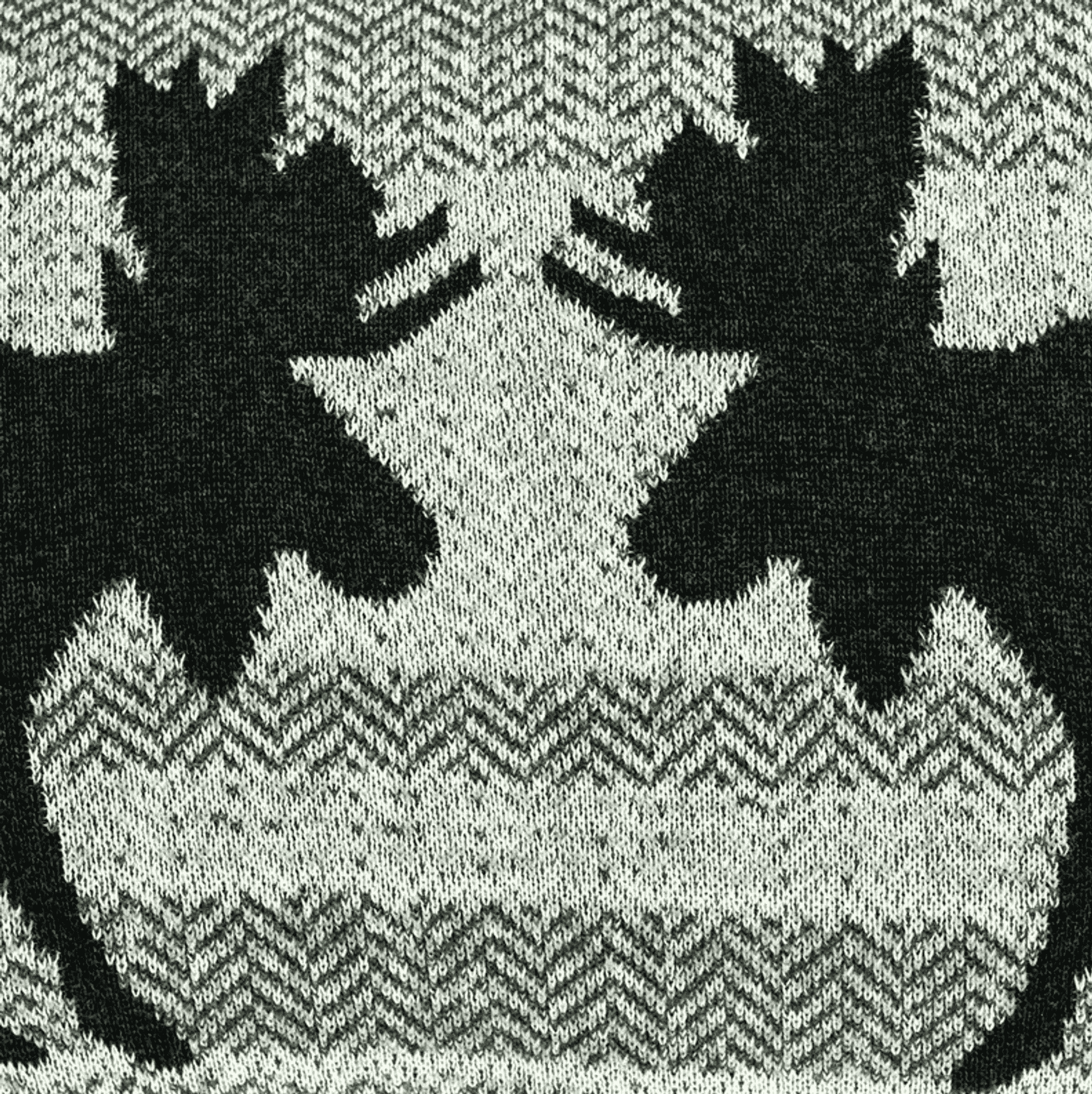 Close-up of black-and-white buck silhouette knit pattern on gray throw pillow