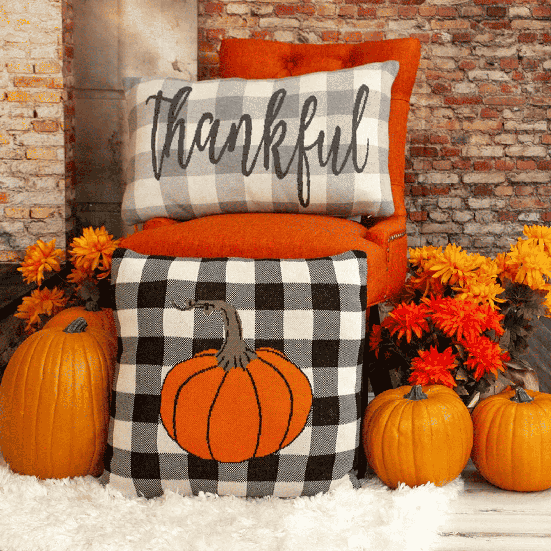 Orange and black-and-white buffalo-check throw pillows with pumpkin and “thankful”
