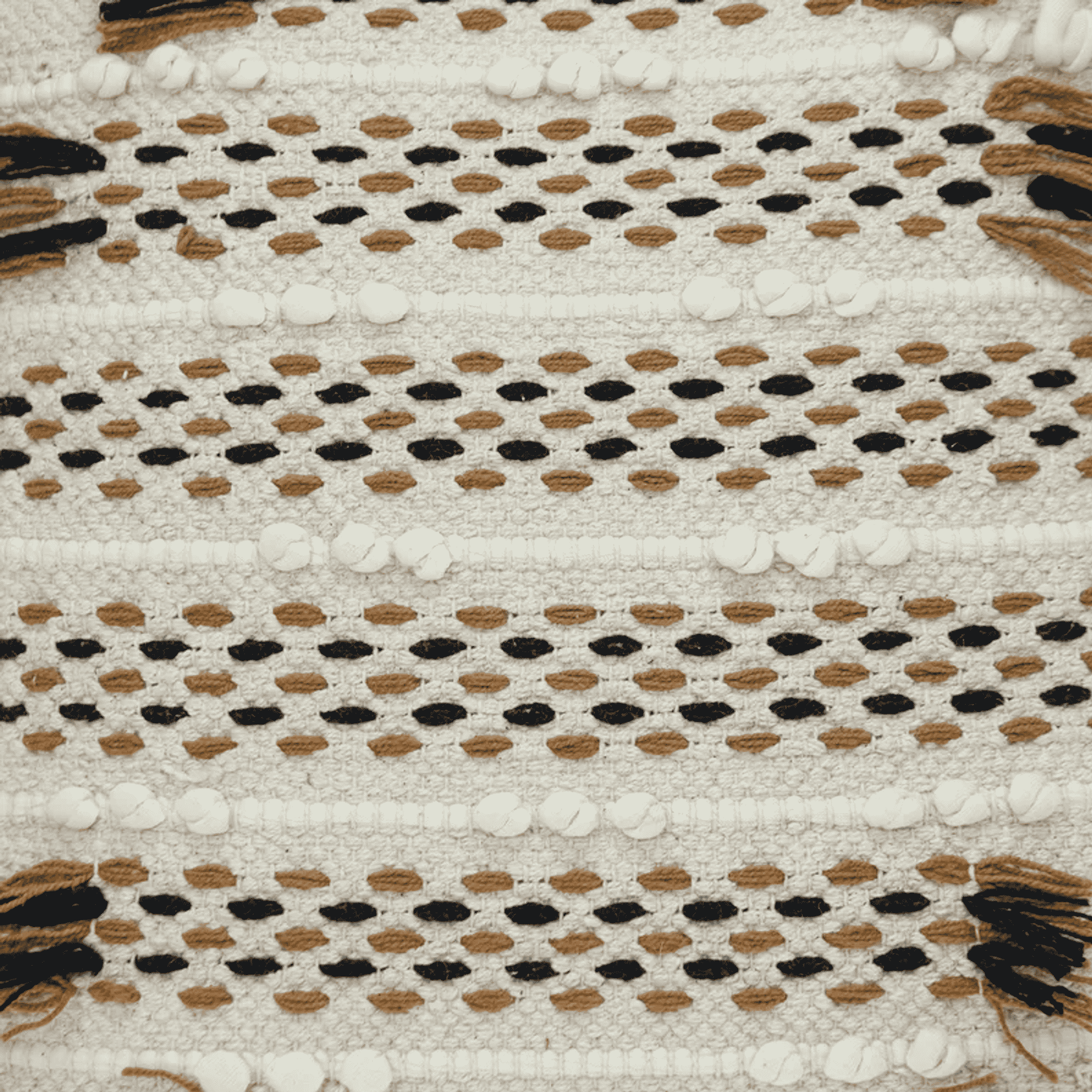 Beige knit throw pillow with dotted geometric pattern and short fringe tassels