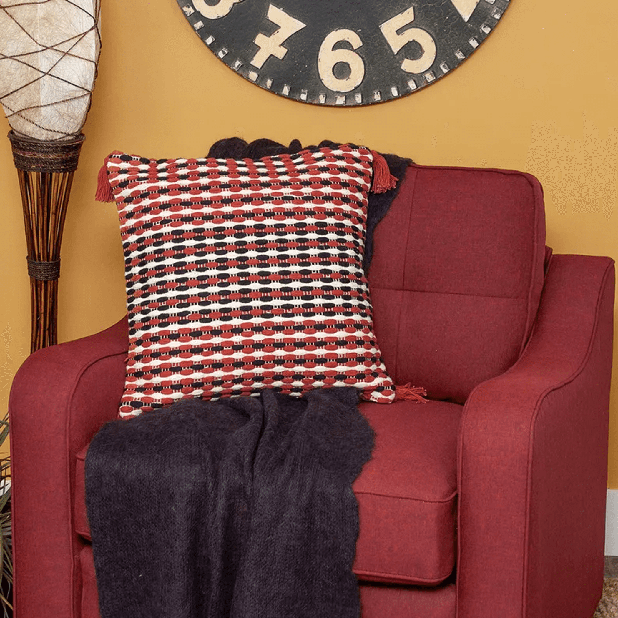 Multicolored patterned pillow cover with tassels and poly insert visible on sofa