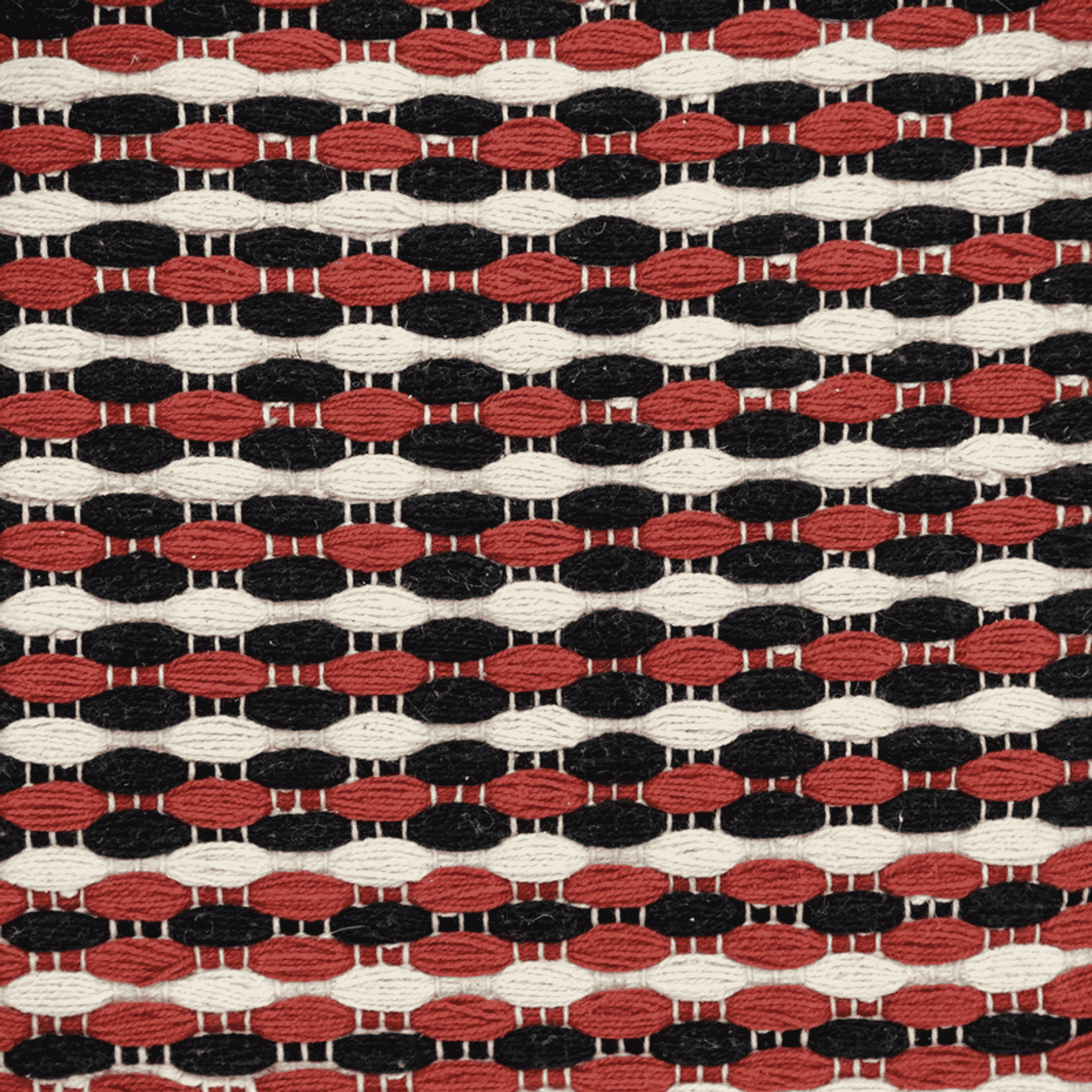Multicolored woven pillow cover fabric close-up with red, black, and cream oval pattern