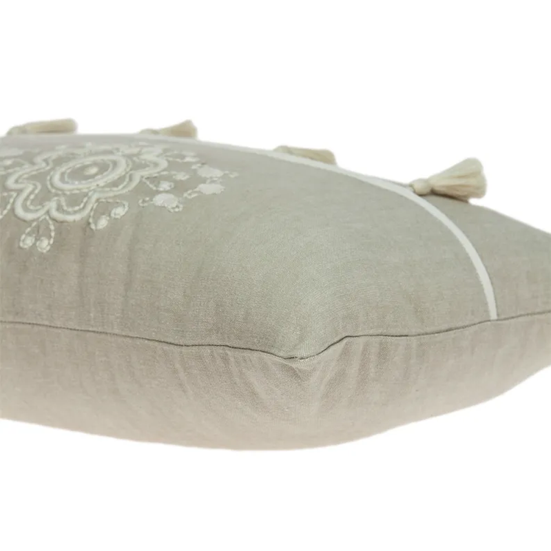 Beige throw pillow with curved seam and white tassels at the top edge