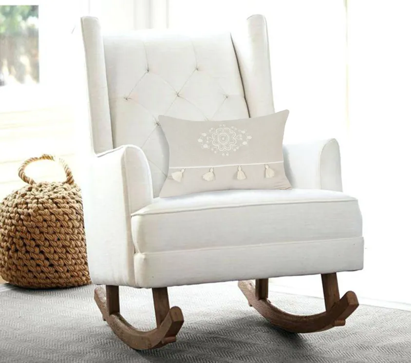Beige throw pillow with white embroidered medallion and tassel fringe
