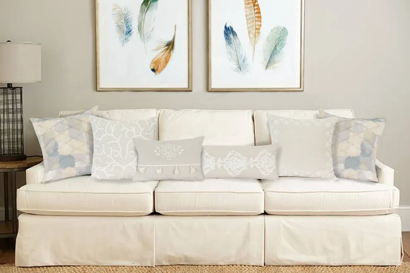 Beige throw pillow with subtle embroidered pattern on a living room sofa