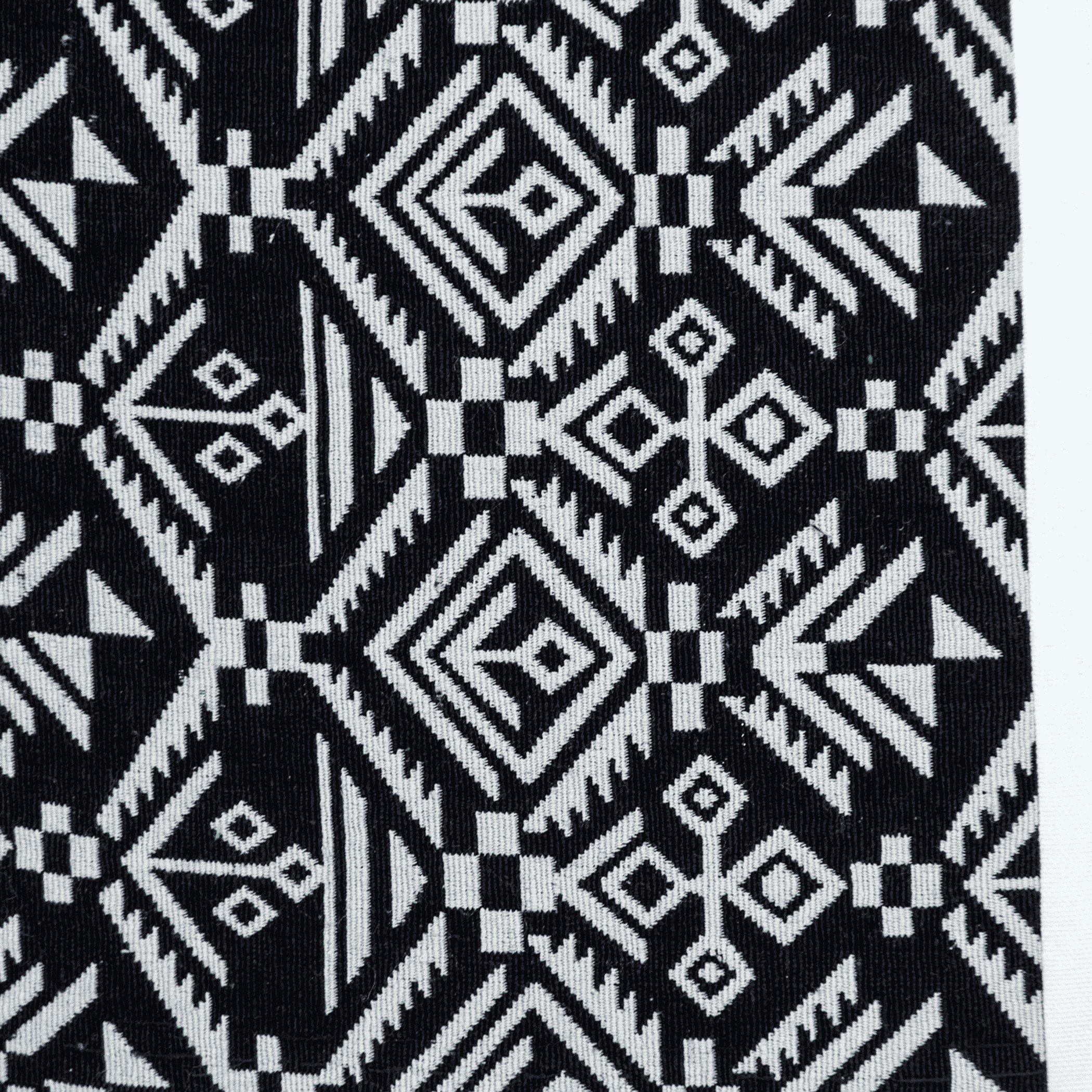 Black-and-white geometric throw pillow fabric close-up with diamond and line motifs
