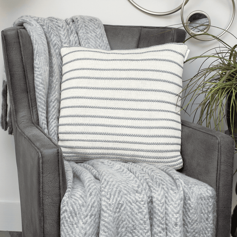 Striped beige throw pillow with dark gray bands, plush knit texture