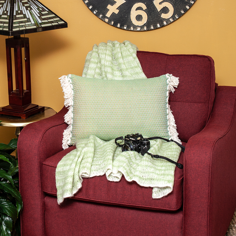 Green accent pillow cover with woven lattice design, cream fringe trim, and insert