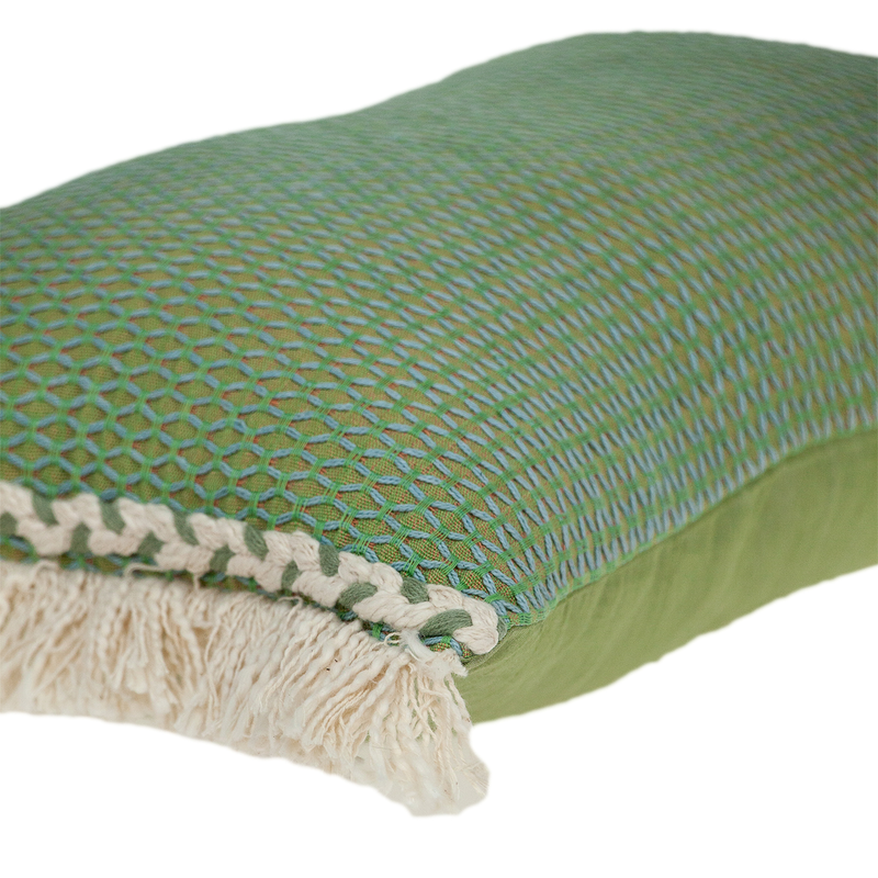 Green woven pillow cover detail with cream fringe trim and lattice pattern