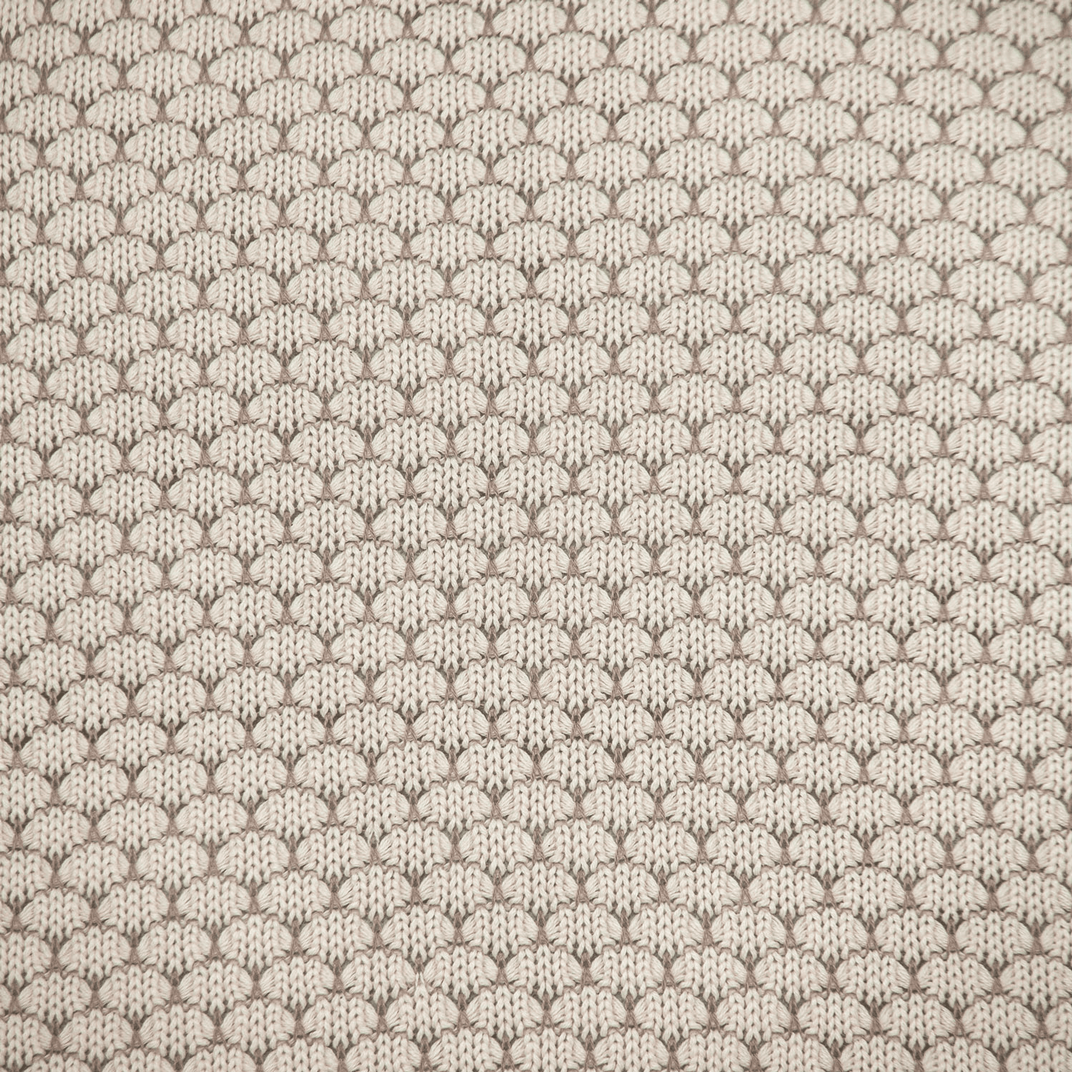 Beige knitted throw pillow fabric close-up with repeating looped pattern