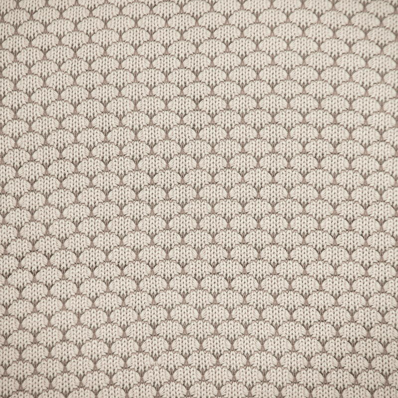 Beige knitted throw pillow fabric close-up with repeating looped pattern