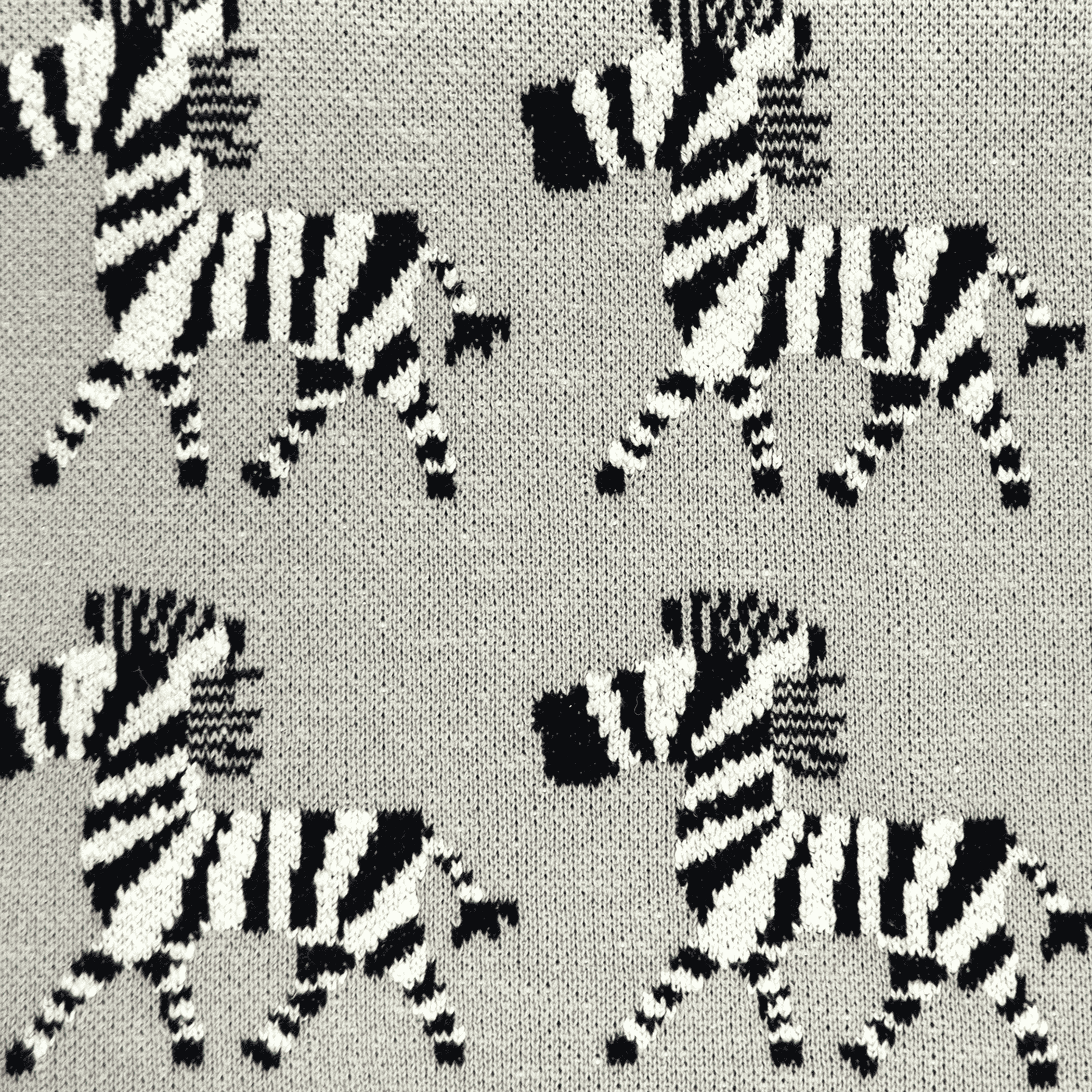 Gray knitted baby blanket with black-and-white zebra stripe pattern