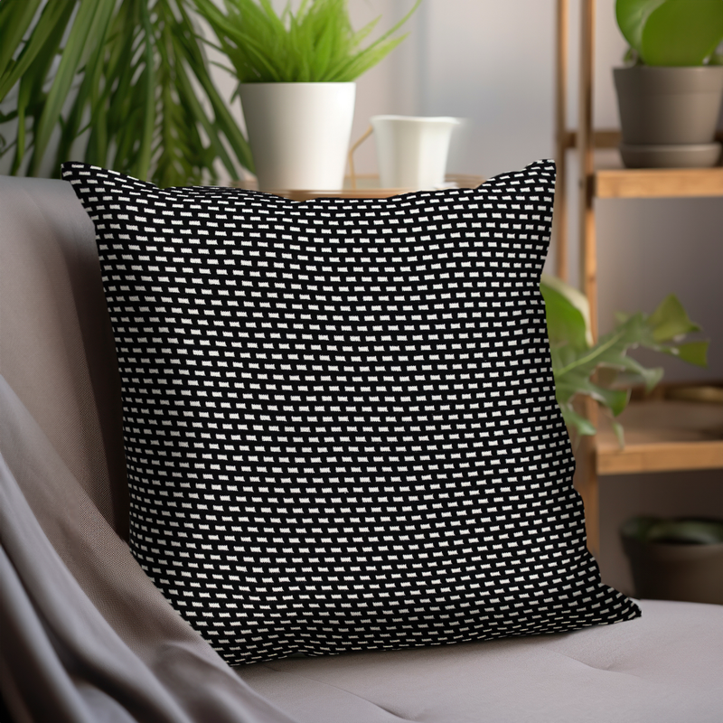 Black and white patterned throw pillow with geometric weave, angled view