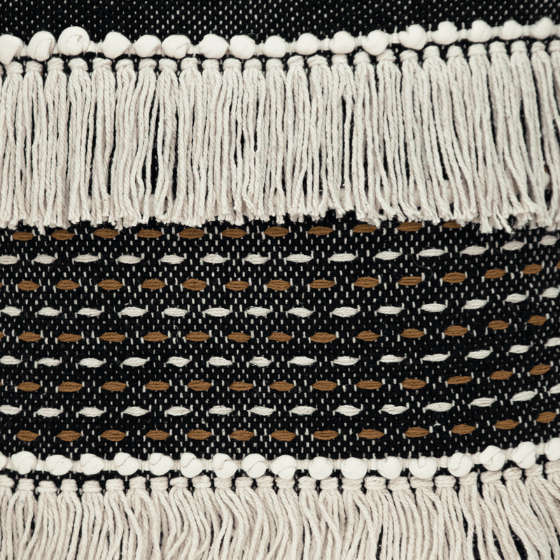 Black and white throw pillow fabric with woven pattern and tassel fringe edge