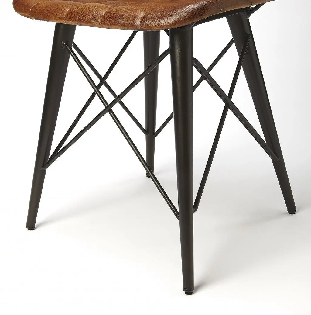 Brown leather upholstered stool with industrial-style black metal legs, featuring a modern crossbar design.
