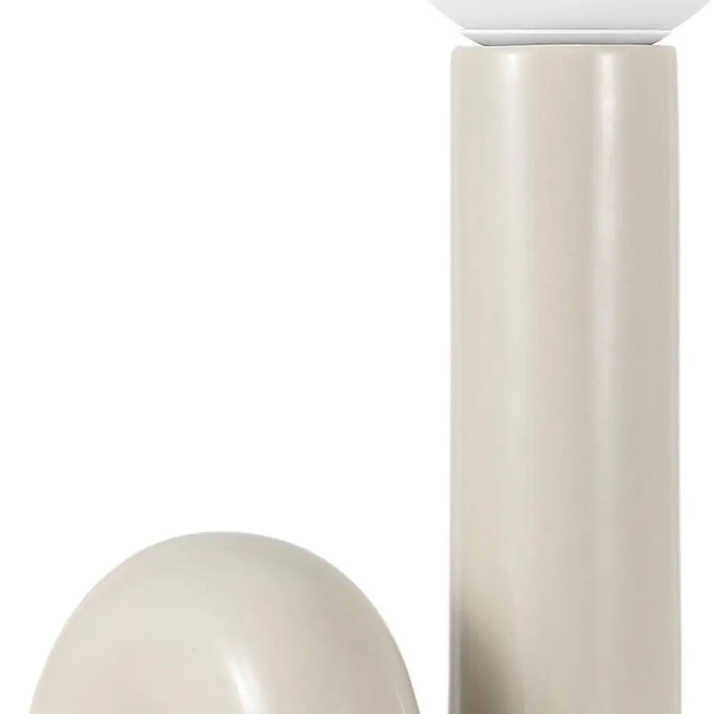Contemporary beige ceramic lamp with sleek cylindrical base and rounded shade, perfect for modern home decor.