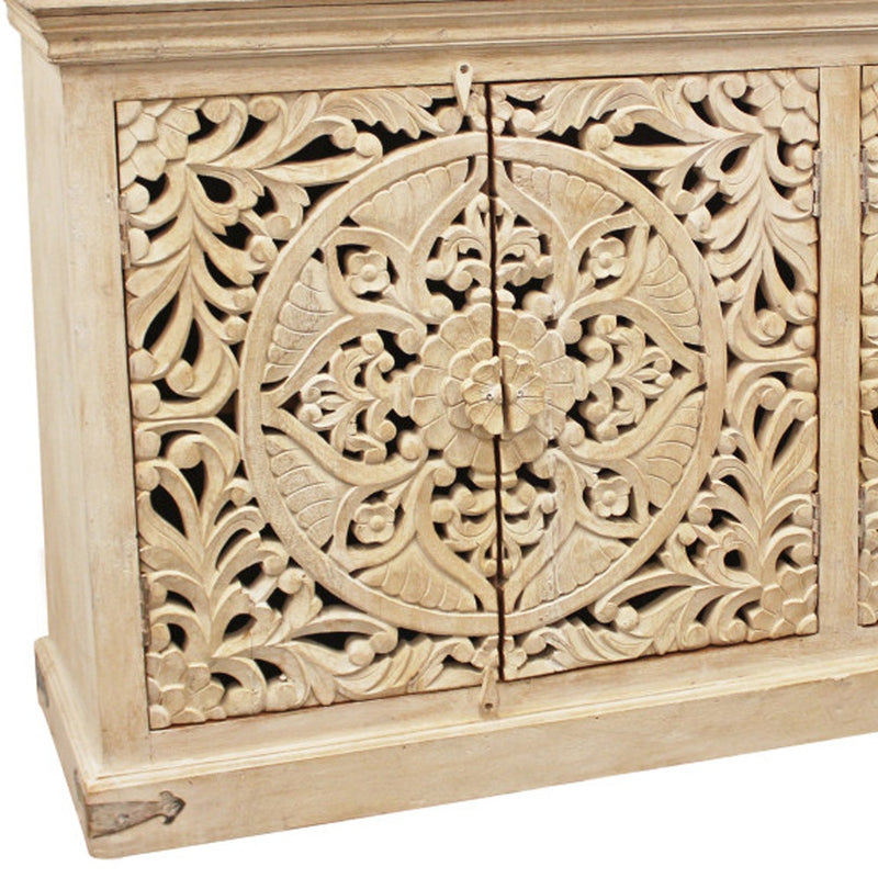 Close-up of beige carved sideboard door with floral scrollwork and decorative hinges.