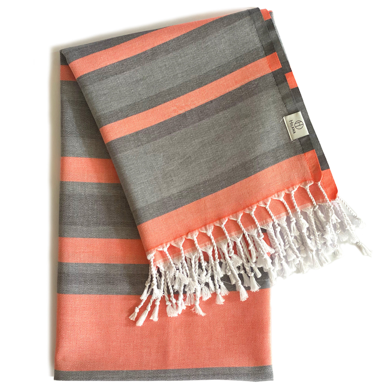 Dark gray Turkish towel with orange stripes and white tassel fringe