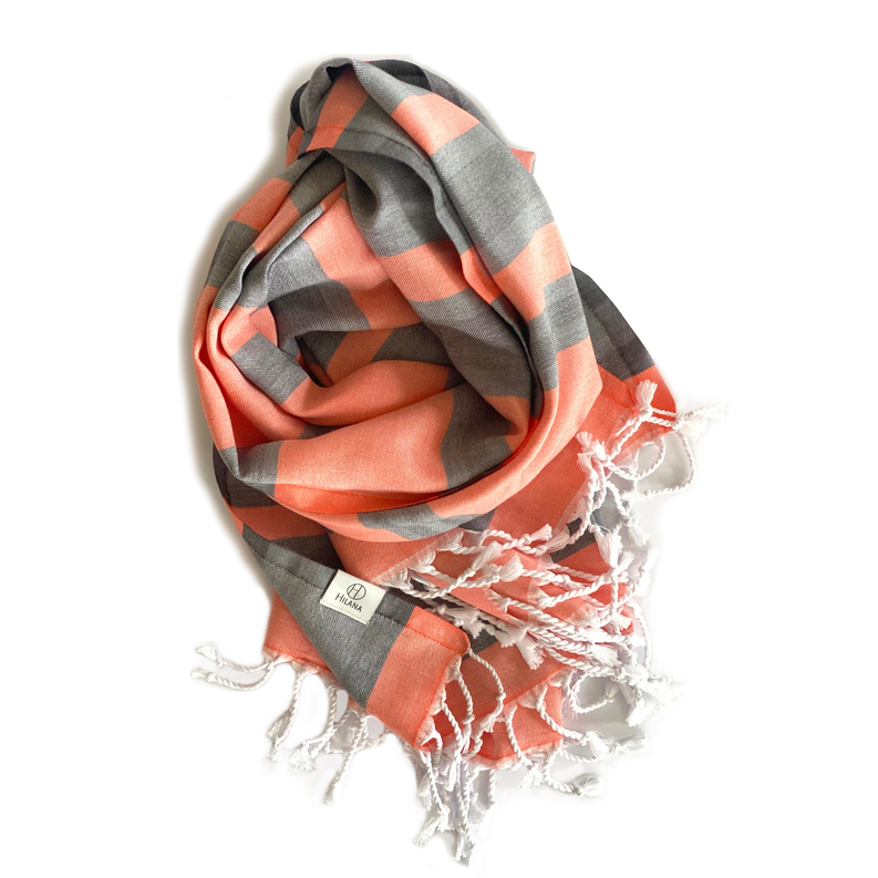 Orange-and-gray striped Turkish towel with white tassel fringe and wrap fold