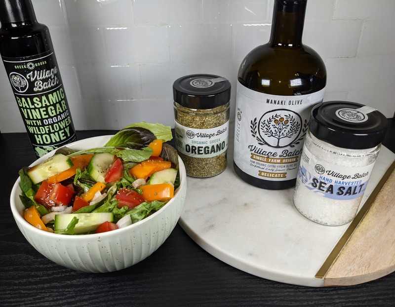 Sea salt jars with black lids and labels, styled with herbs and vegetables