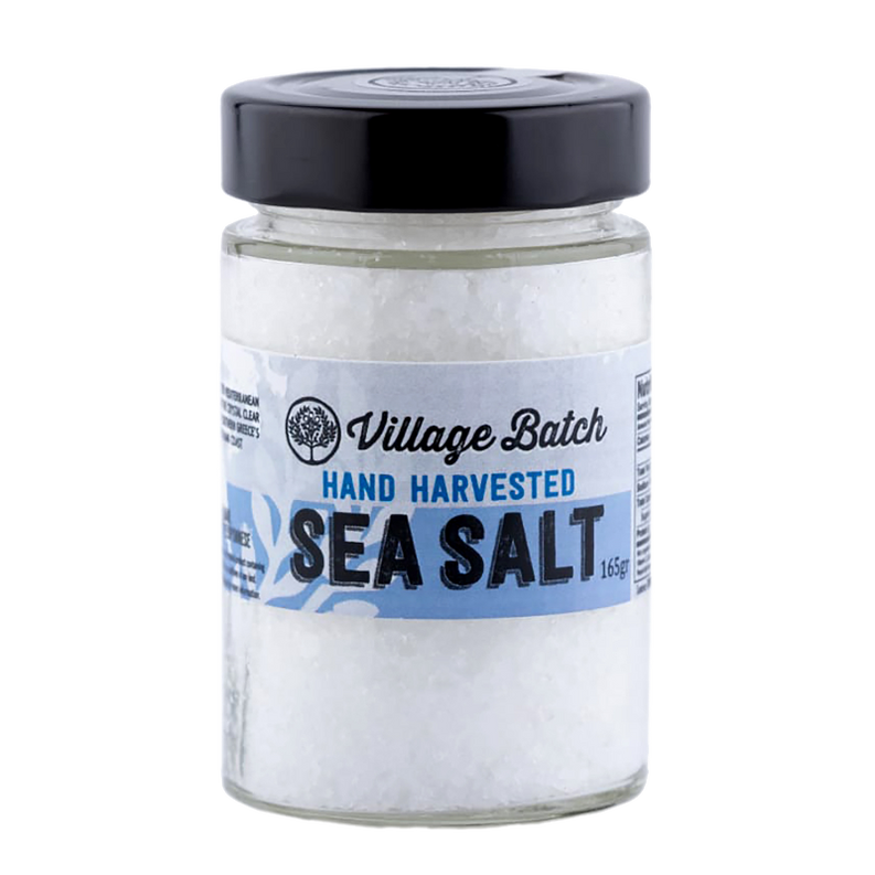 Sea salt jar with black lid labeled Village Batch Hand Harvested Sea Salt