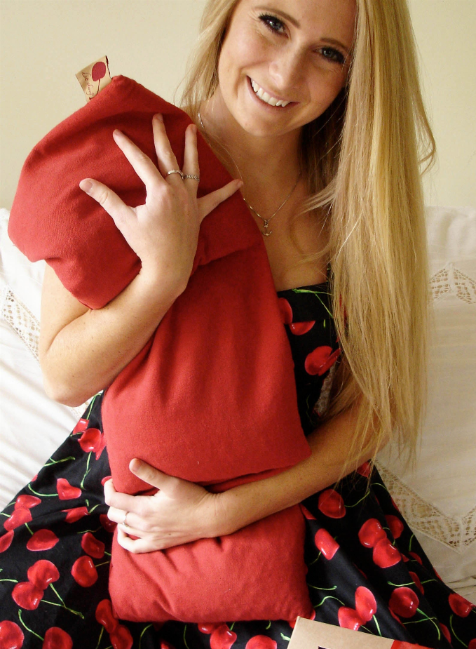 Red plush triple-square throw pillow held by a smiling woman