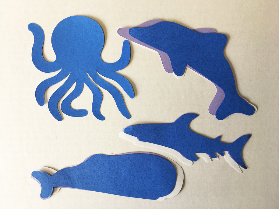 Blue sea animal cut-outs including octopus, whale, dolphin, and fish shapes