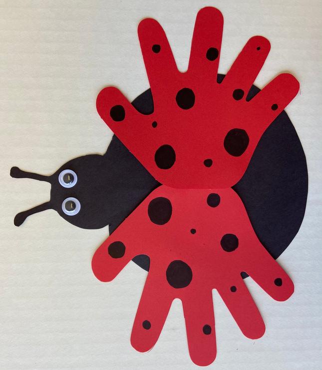 Red hand-shaped cut-out with black dots, dark side pieces, and small bead accents