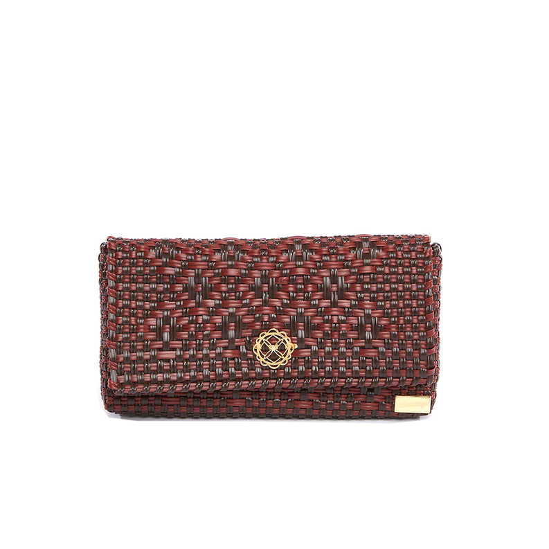 Woven travel tote clutch with red-and-brown geometric pattern and gold emblem