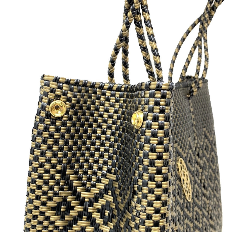 Woven tote corner detail with gold hardware and braided handle knots