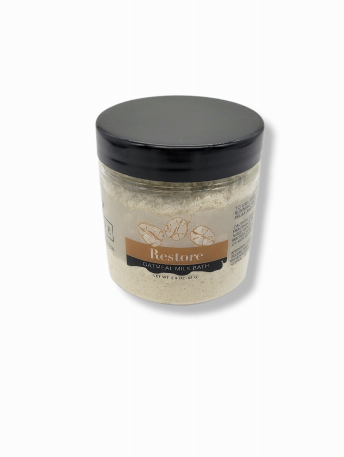 Milk bath soak jar with oatmeal restore label, black lid, pale powder contents.