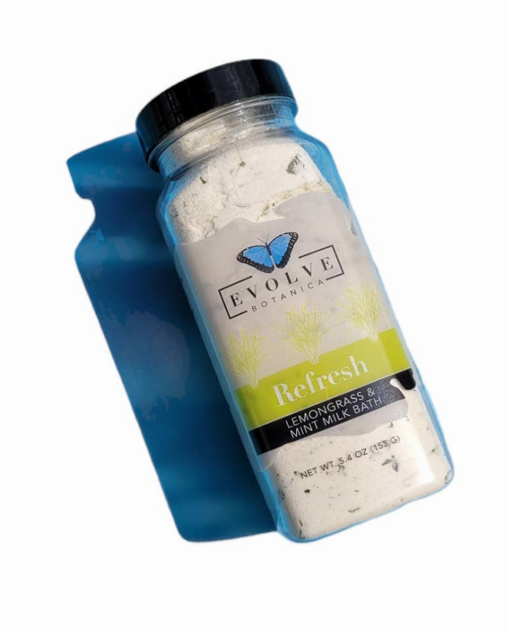 Milk bath soak bottle with lemongrass & mint label, black cap, filled with pale powder.