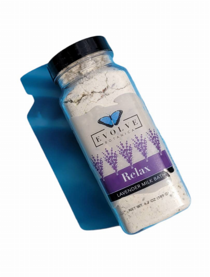Milk bath soak bottle with lavender label, black cap, pale dry powder inside.
