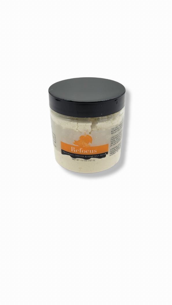 Small milk bath jar with black lid and white bath powder, label facing front