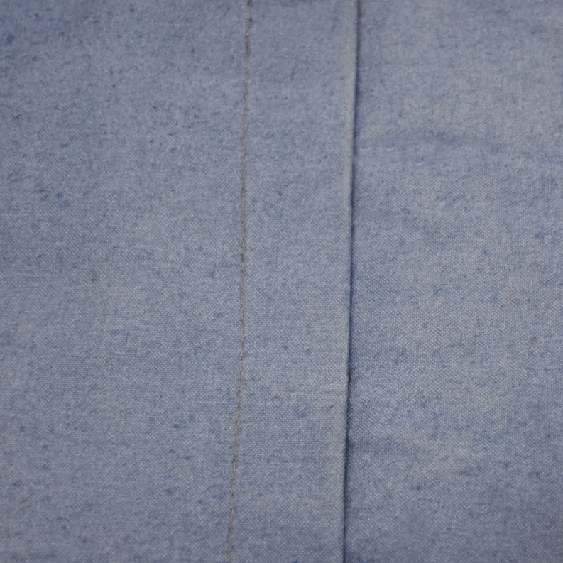 Close-up of blue fabric top panel with seam lines and stitched edge.
