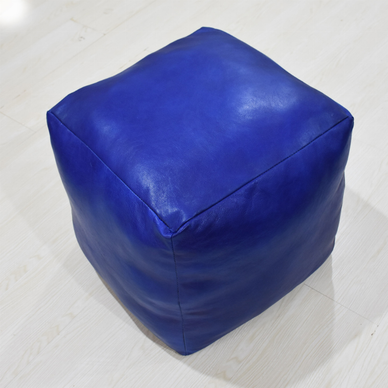 Blue leather square pouf with top seam detail and rounded corner edges.