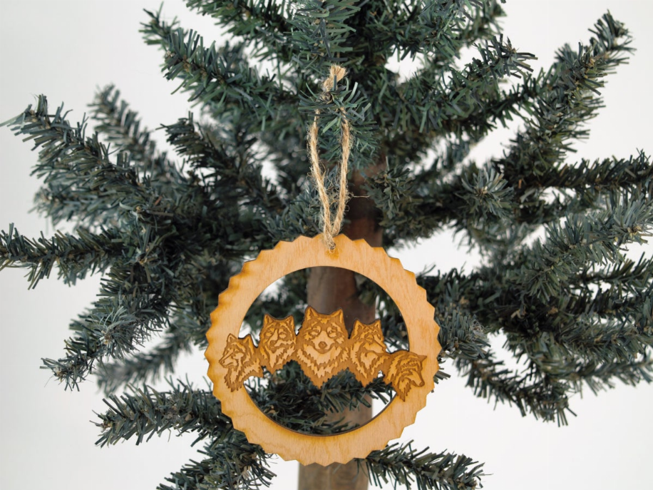 Unfinished wooden tree ornament, wolf pack silhouette in circular cutout with hanging twine