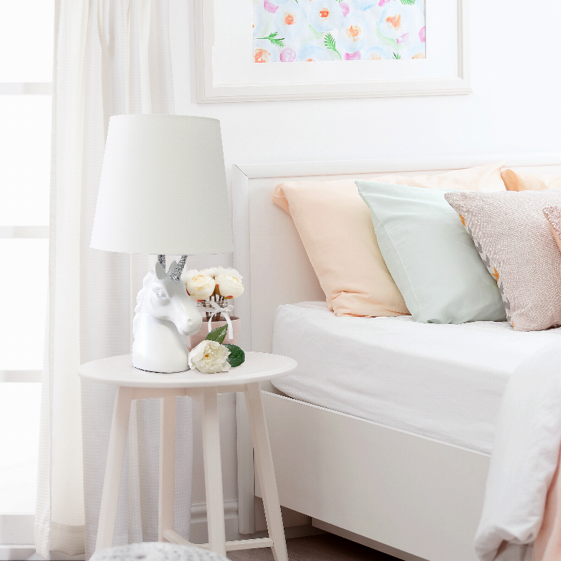 Unicorn table lamp with white shade and silver glitter horn on a small pedestal