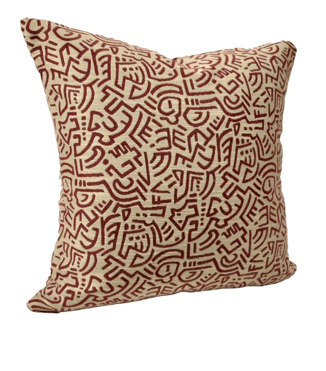 Tan throw pillow cover with red and rust geometric maze line pattern