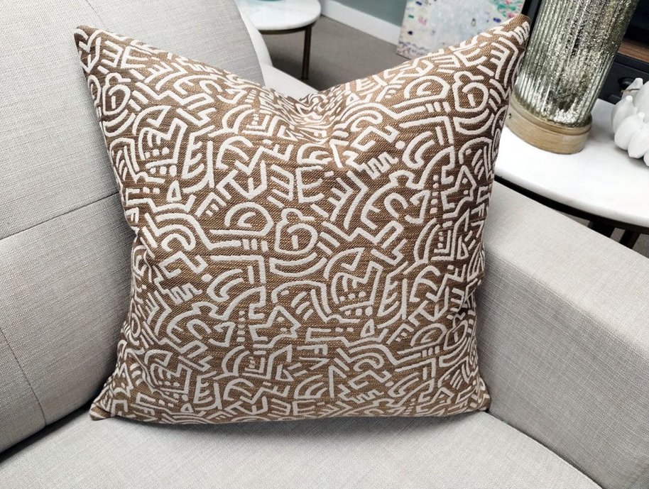 Pop Energy throw pillow in tan with white abstract line maze pattern