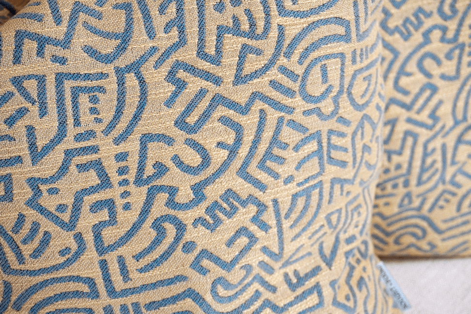 Light blue throw pillow cover with tan geometric maze pattern and lines